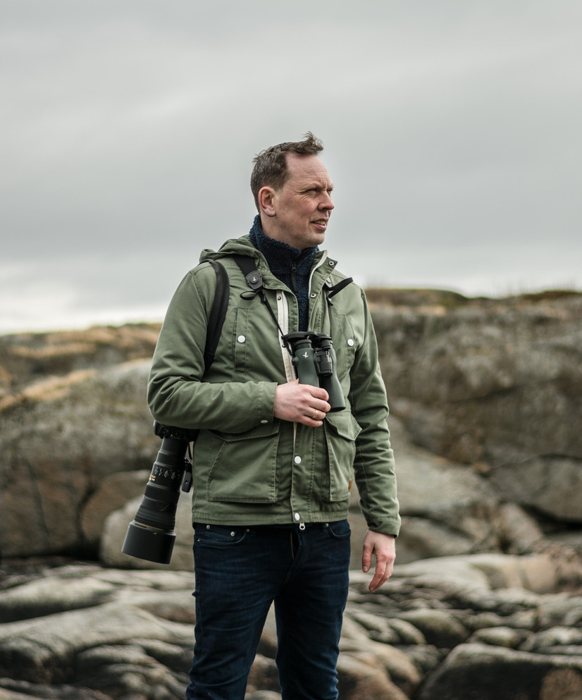 Martin Eggen fotografert i fjøra med fuglekikkert og fotoapparat. Foto: Jon Olav Larsen