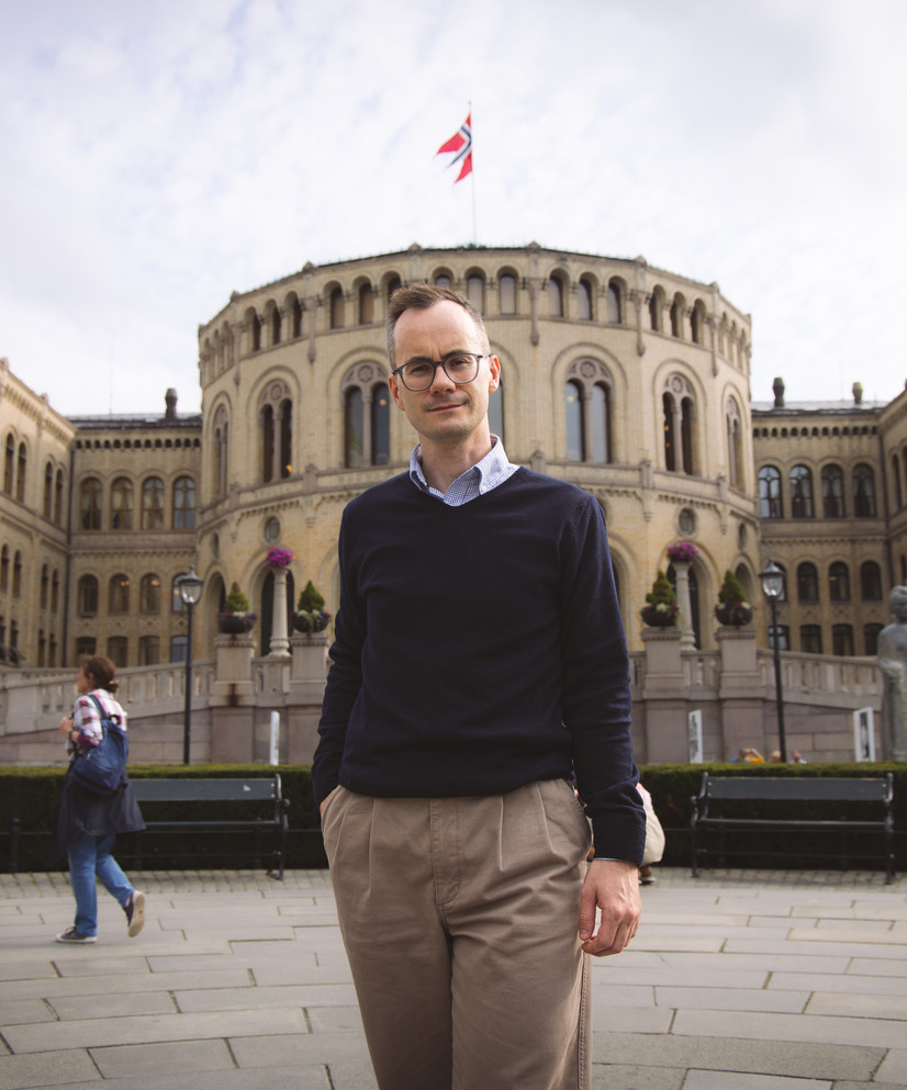 Jonas Maas Nilsen, nestleder og skolepolitisk talsperson i MDG, ymter om satsing på lærebøker i årets budsjettforhandlinger. Avbildet foran Stortinget. Foto: Ane Skarvøy / MDG