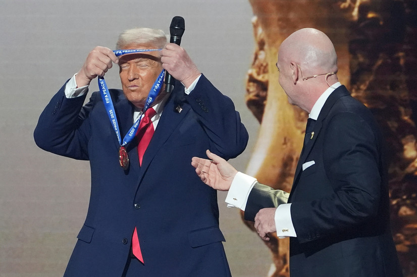 Donald Trump tek på seg vinnarmedaljen for den første fredsprisen frå Fifa, overlevert av Fifa-president Gianni Infantino under VM-trekninga 5. desember 2025. Foto: AP Photo / Evan Vucci, File 