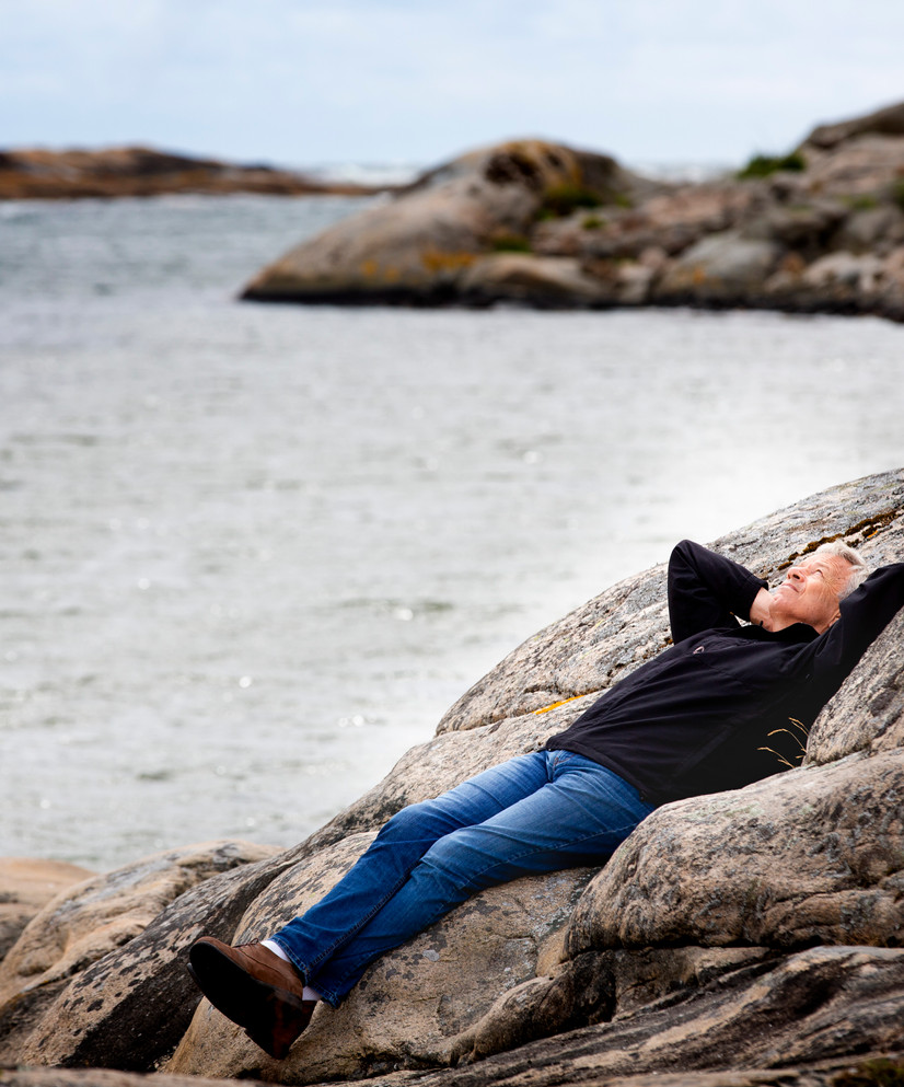 Øystein Olsen ligger på et svaberg.