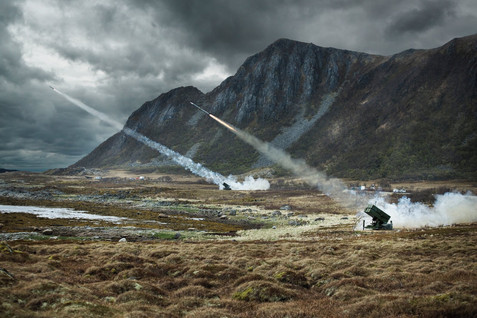 Bilde av utskyting av rakettar i eit fjell-landskap.